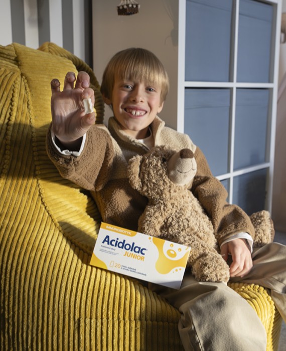 Chłopiec trzyma w rękach misio-tabletkę Acidolac