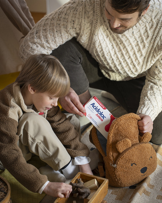 Tata z synem, tata trzyma w rękach opakowanie Acidolac Junior